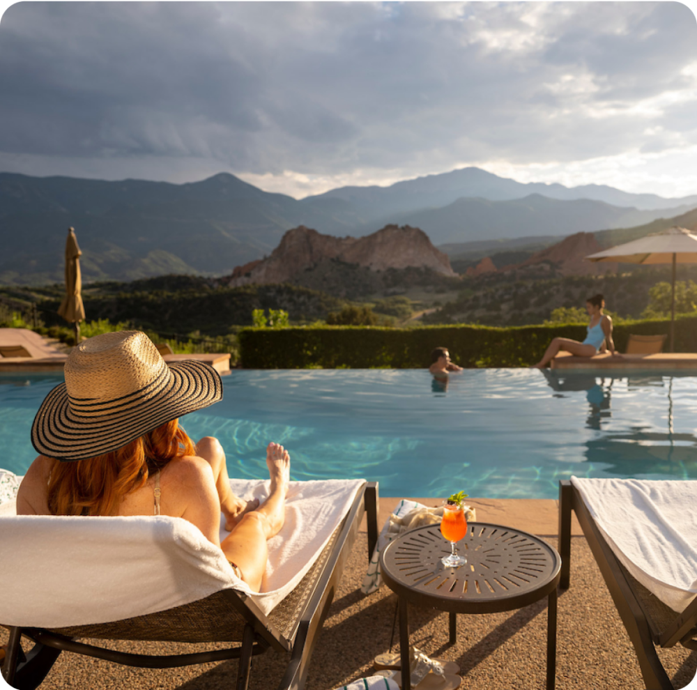 A woman sitting poolside at the Garden of Gods swimming pool.